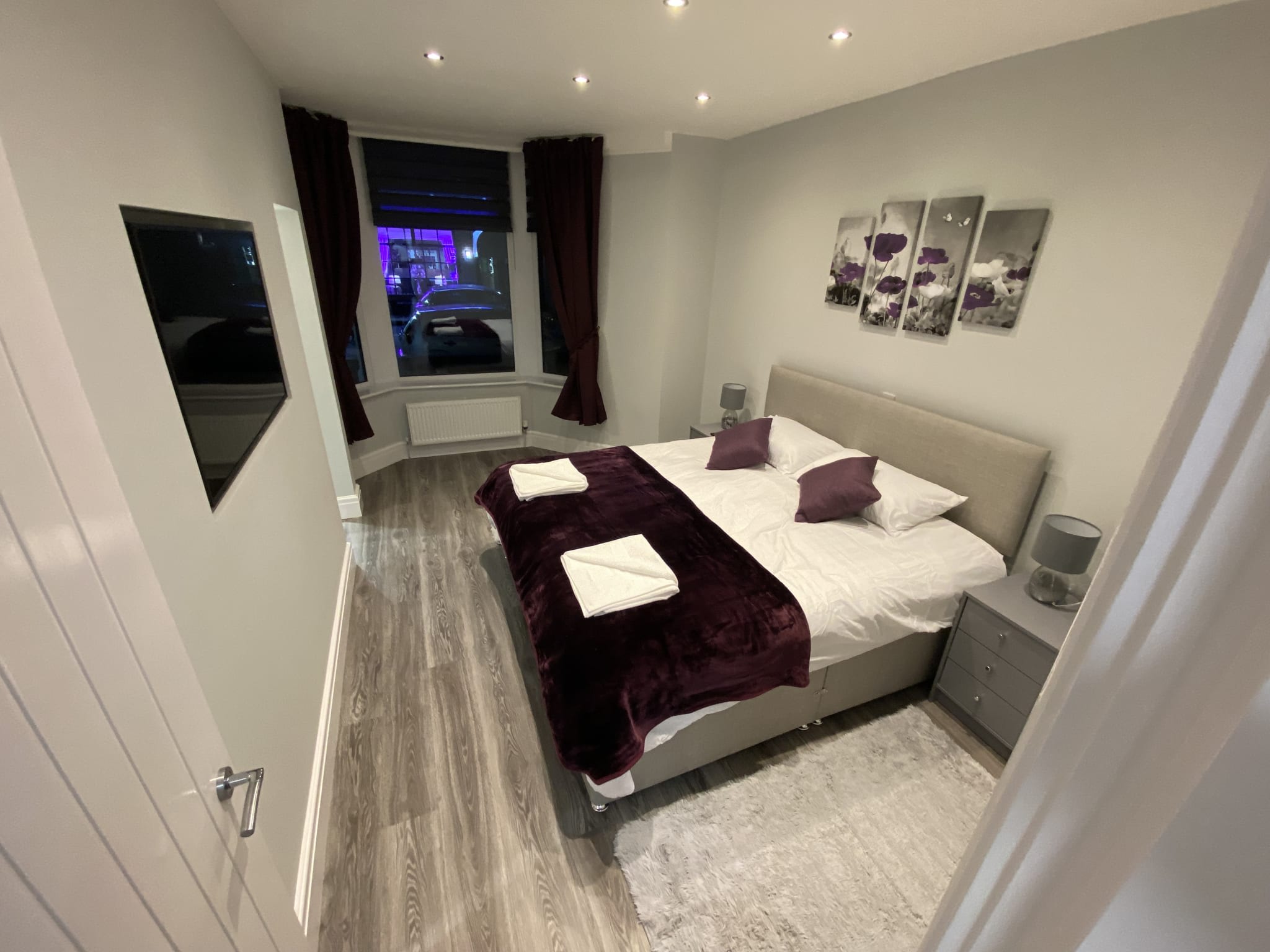 South Apartment bedroom with plum throw and cushions