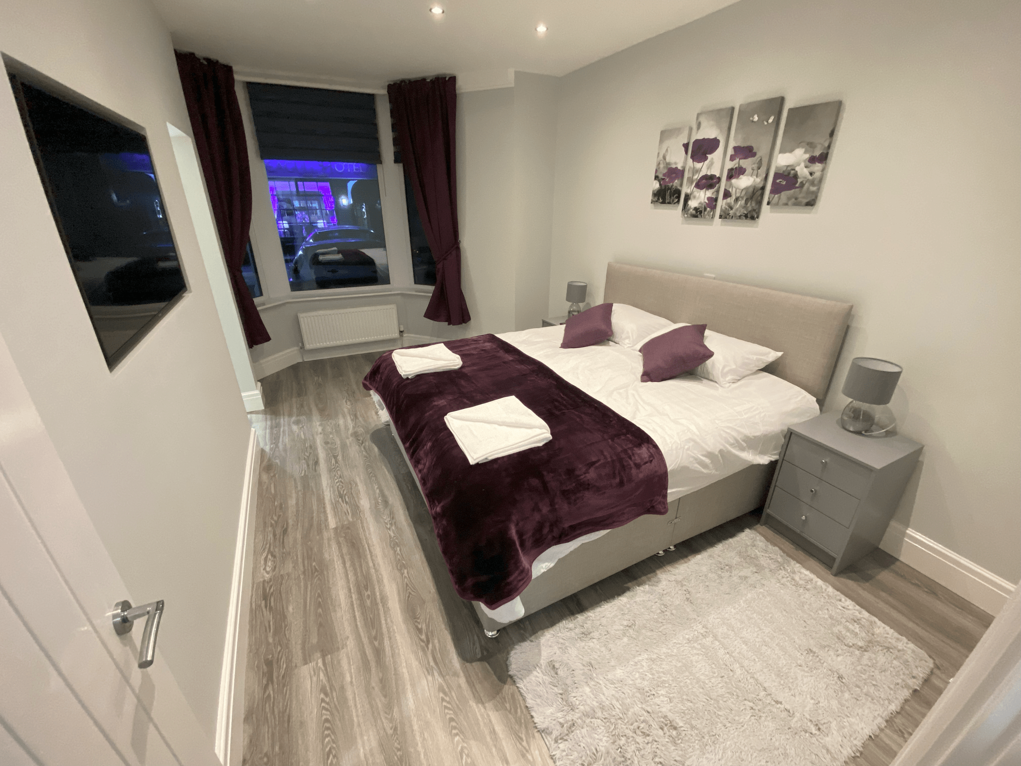 Bedroom with bay window and plum curtains
